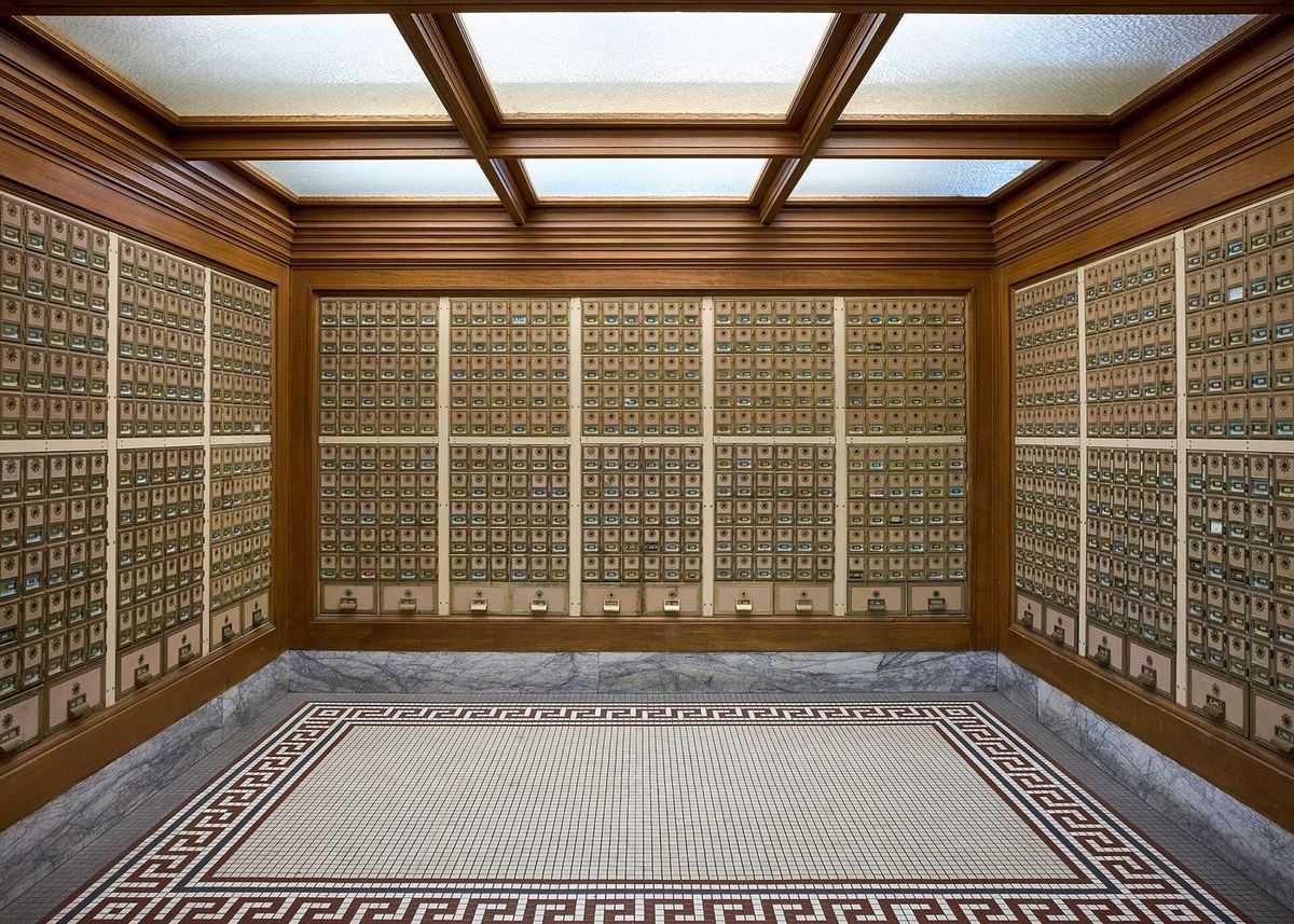 A room lined with hundreds of identical numbered post-office boxes